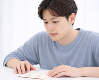 貯金通帳を眺める男性